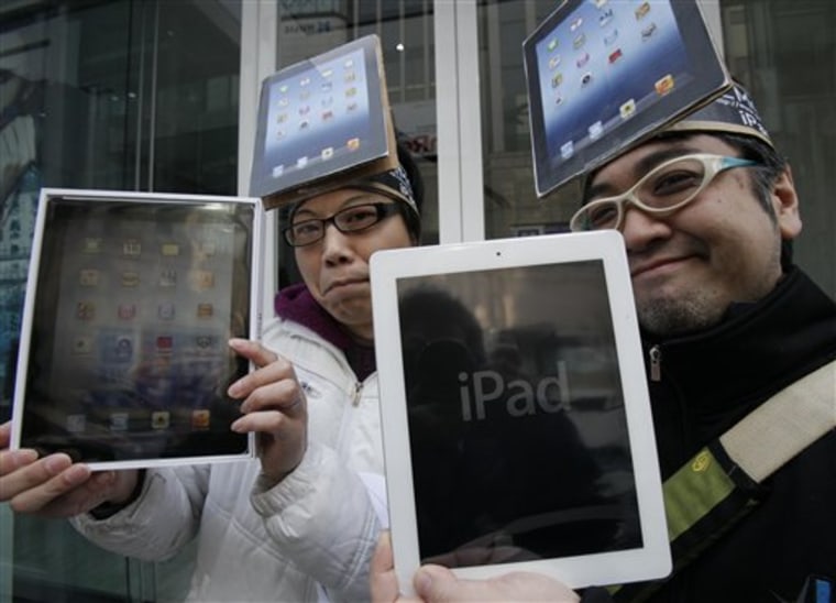 Japanese Ryota Musha, 41, right, and Hisanori Kogure, 31, show off new iPad tablet computers they purchased, in Tokyo Friday, March 16. Sales of the third version of Apple's iPad began Friday morning in Japan. 